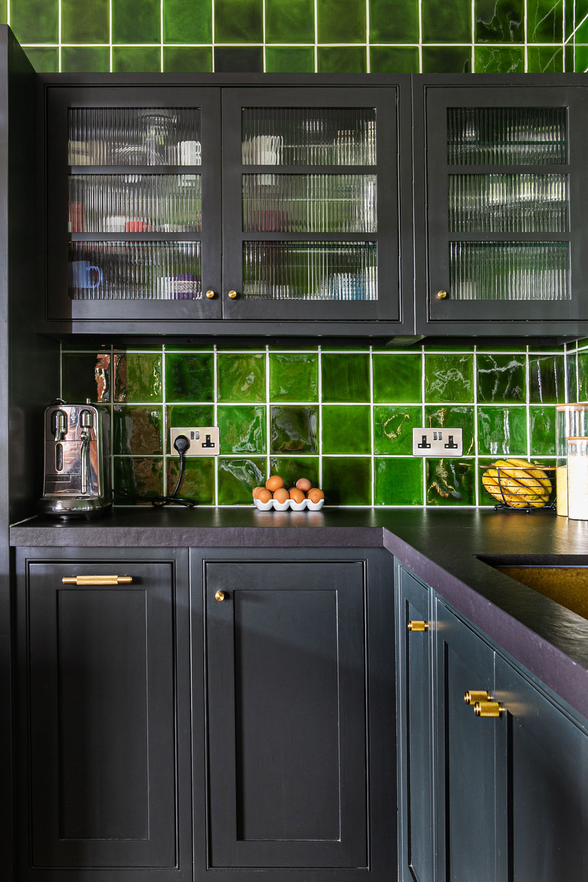 Glazed wall cabinets painted in lamp black with fluted glass