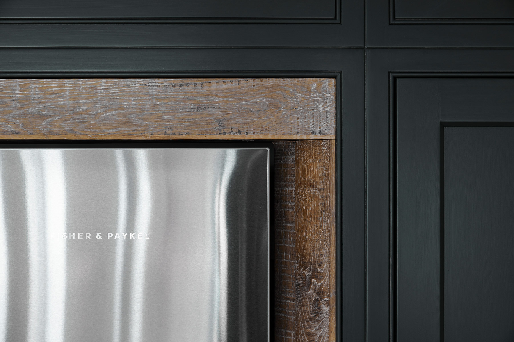 Fisher + Paykel stainless steel fridge freezer against reclaimed oak surround