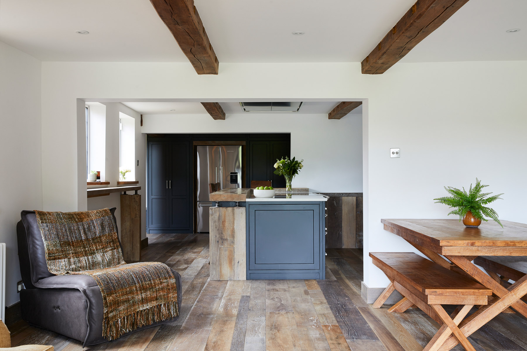 Open plan kitchen with reclaimed flooring and bespoke painted kitchen