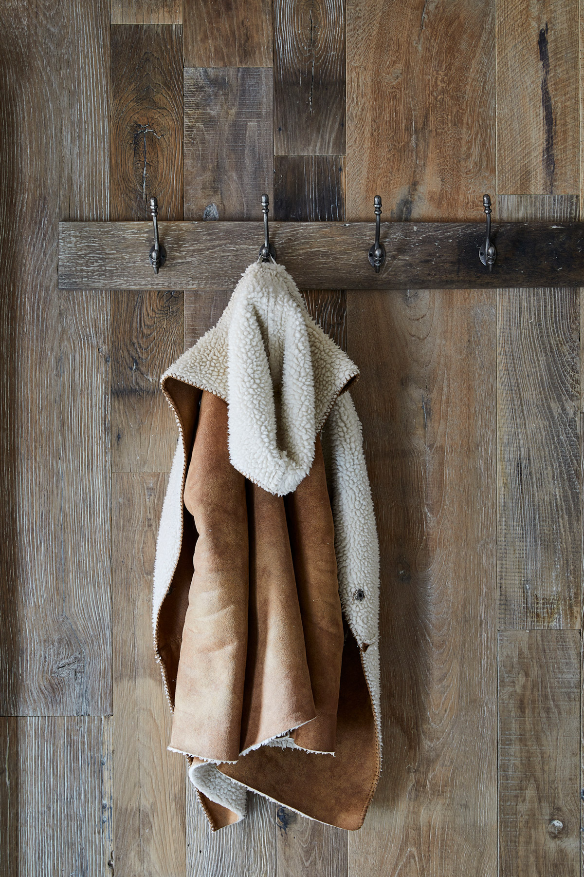 Coat hung on wall covered in reclaimed oak cladding