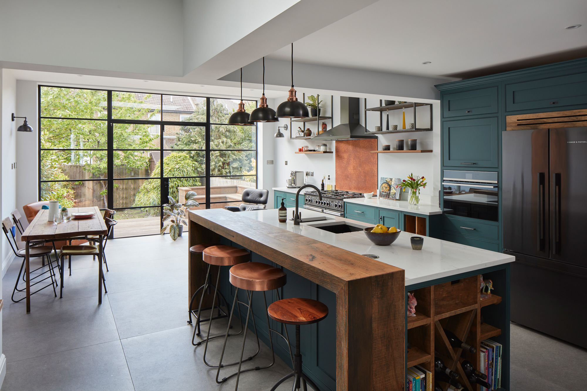 Wrap around breakfast bar with painted teal kitchen cabinets