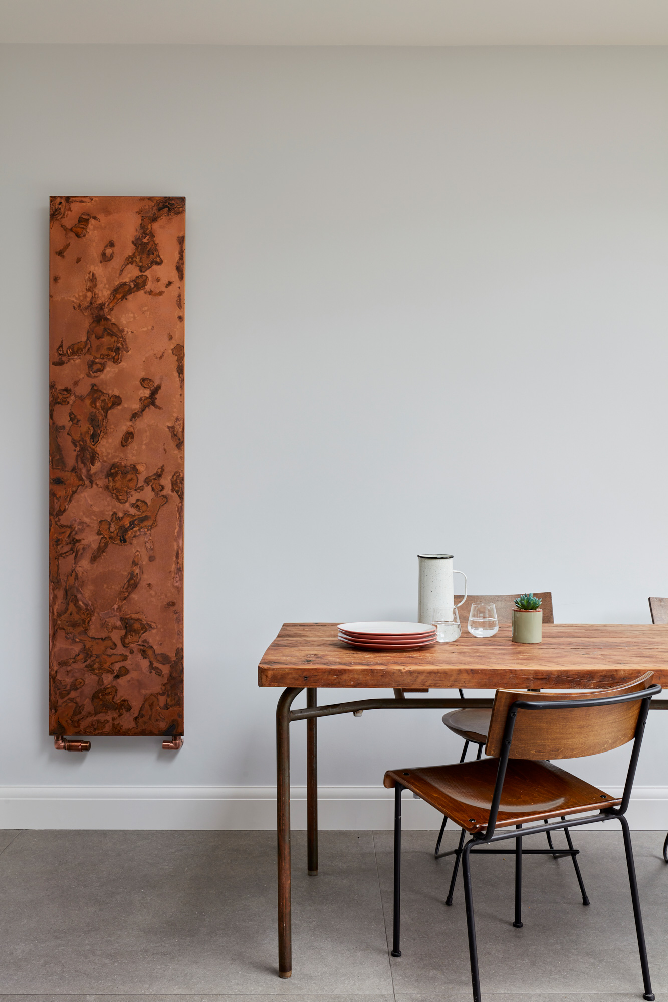 Exposed copper radiator with reclaimed oak table