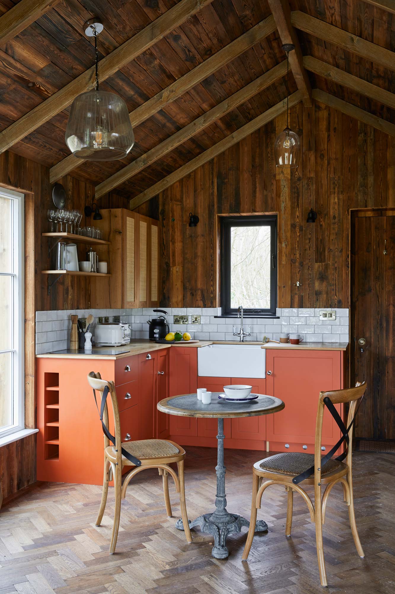 Orange kitchen in treehouse with reclaimed wall clad