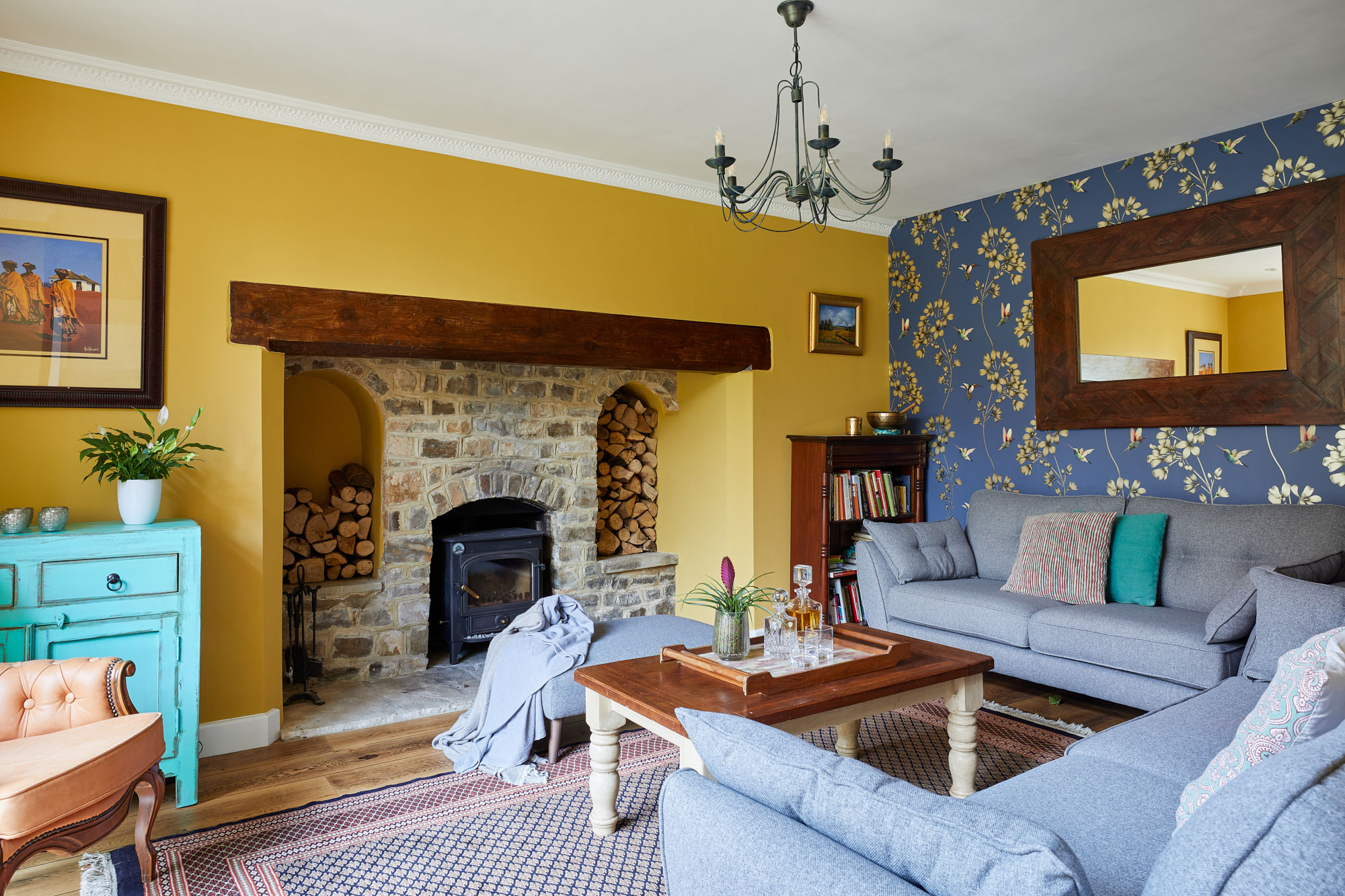 Bright yellow living room with feature wallpaper wall