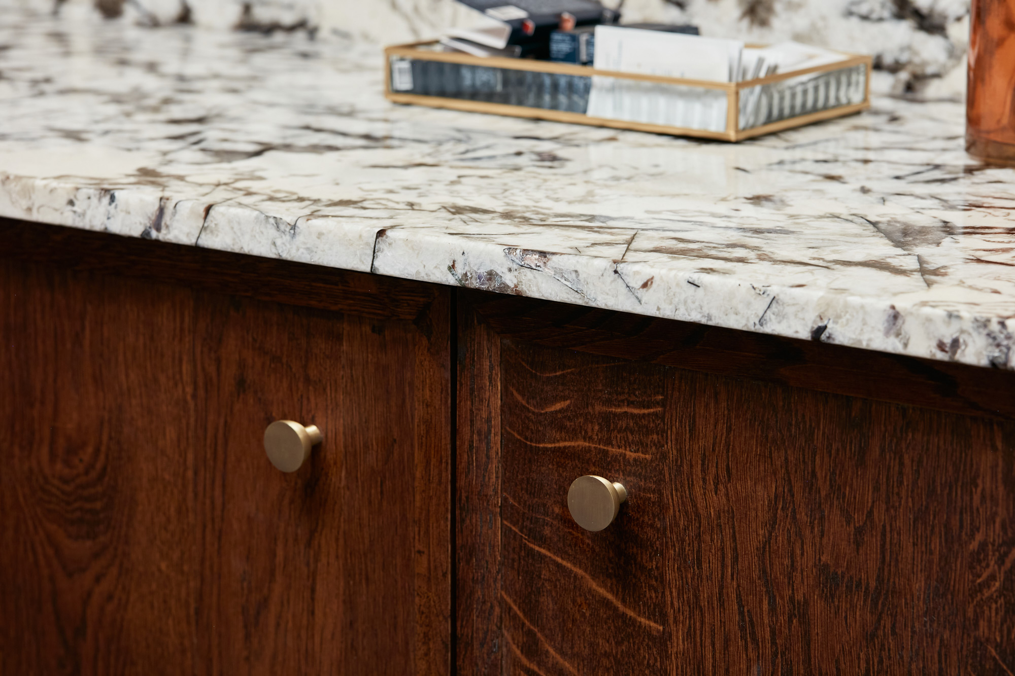 Simple turned brass cabinet handle and granite worktop on bespoke oak units