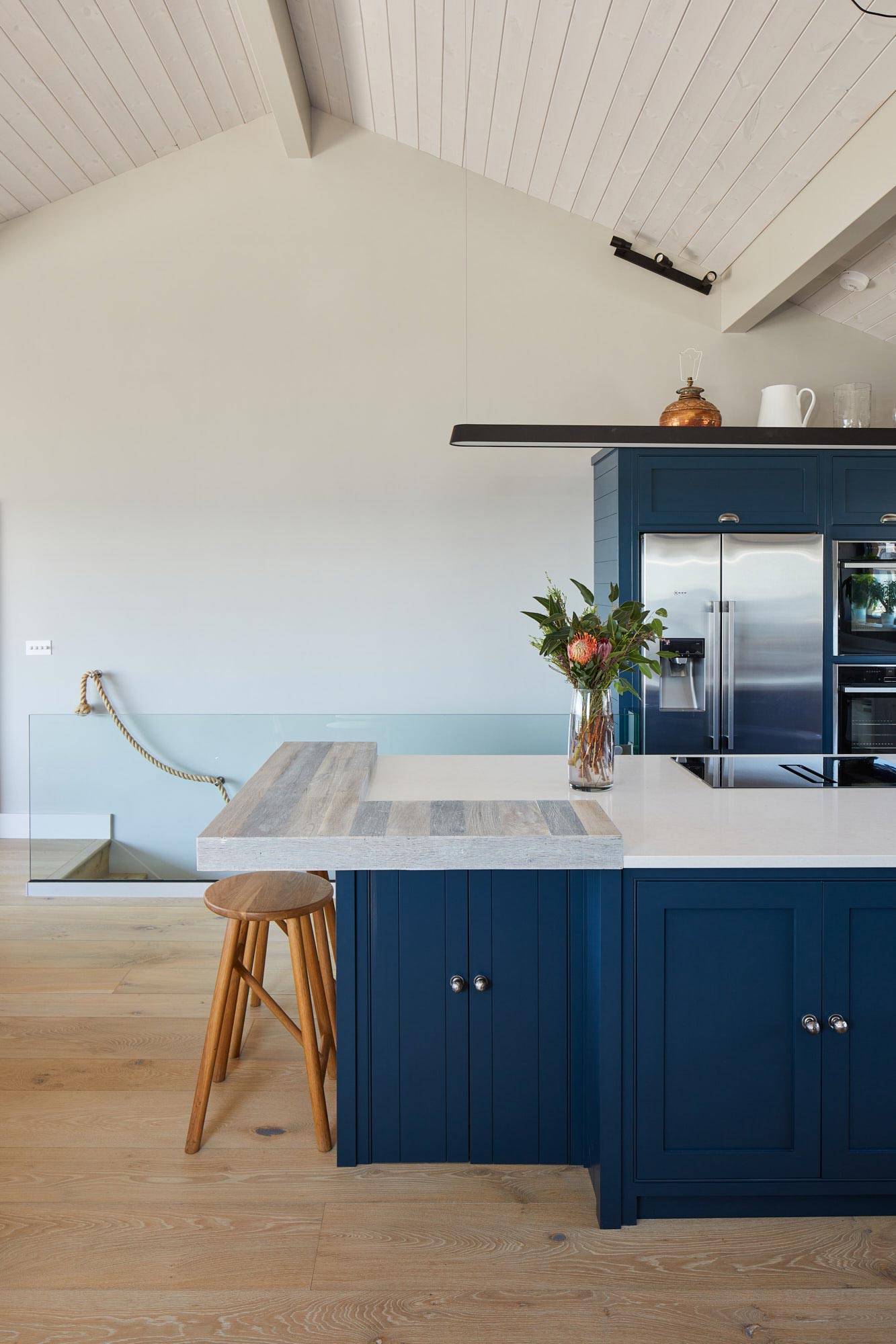 Bespoke blue kitchen island with two oak bar stools