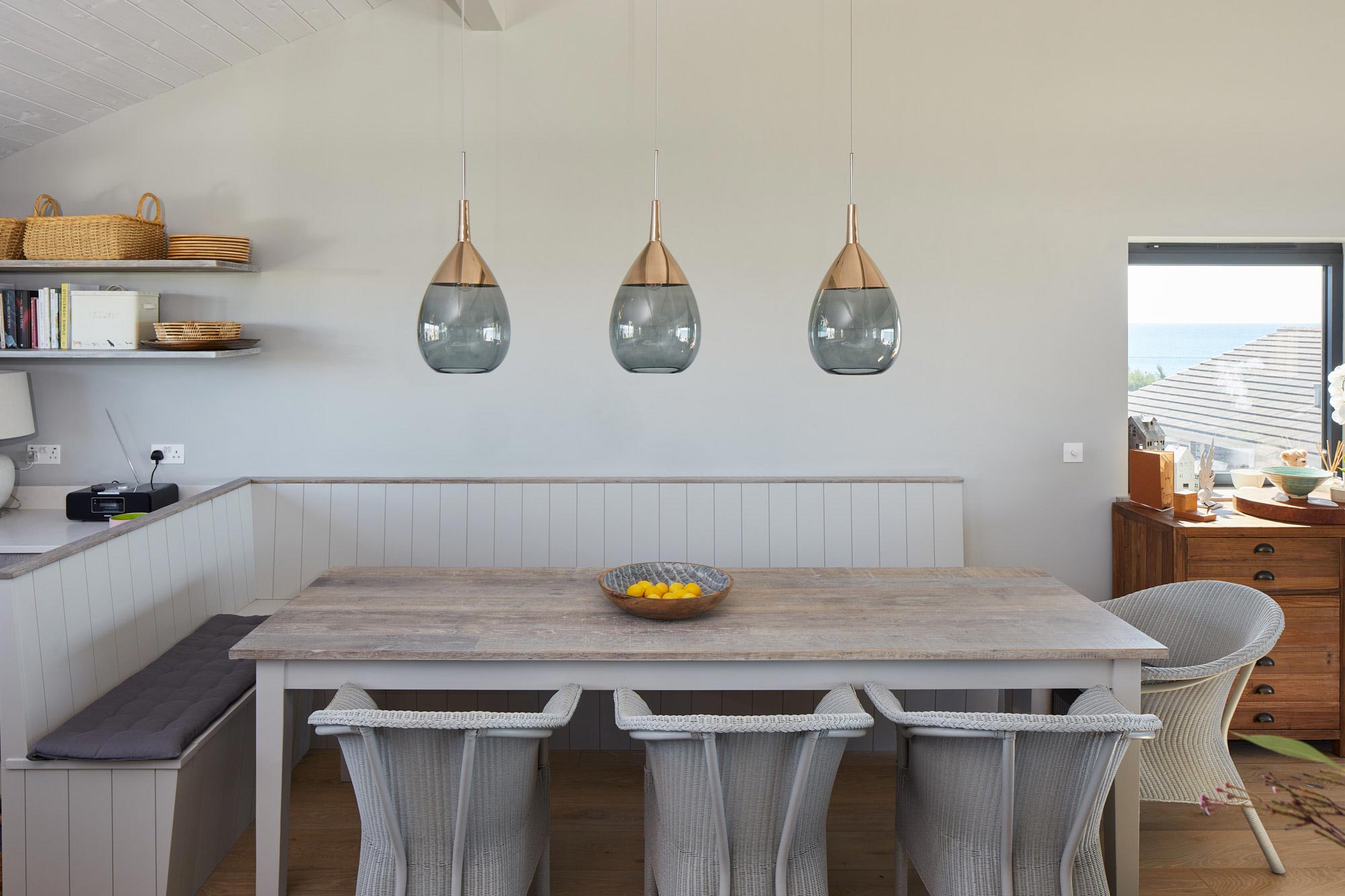 Glass pendant lights above reclaimed oak dining table