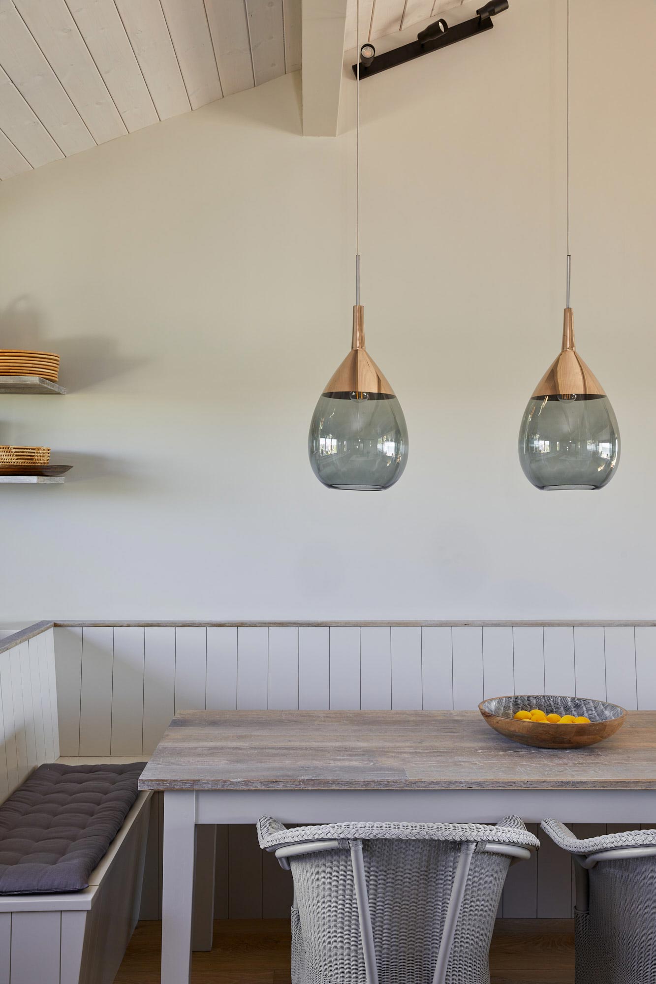 Glass pendant lights illuminate bespoke dining table