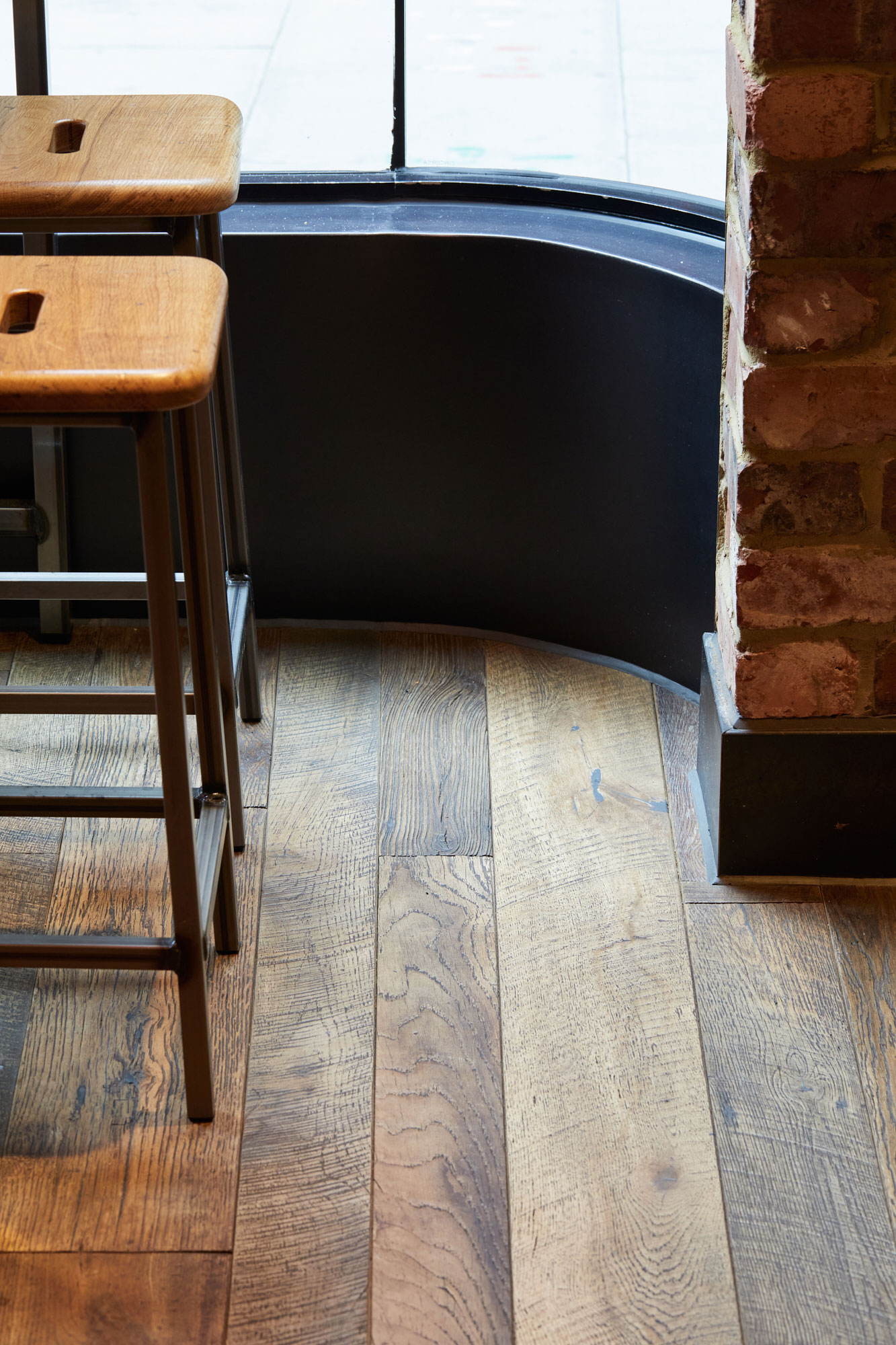 Scribed oak wood floor boards around curved window