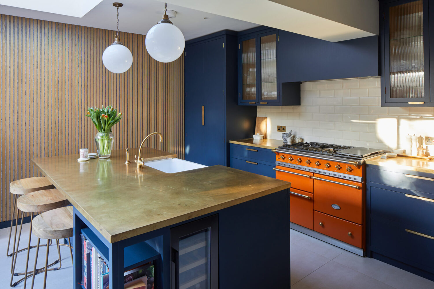 Blue kitchen island with bright orange classic range cooker