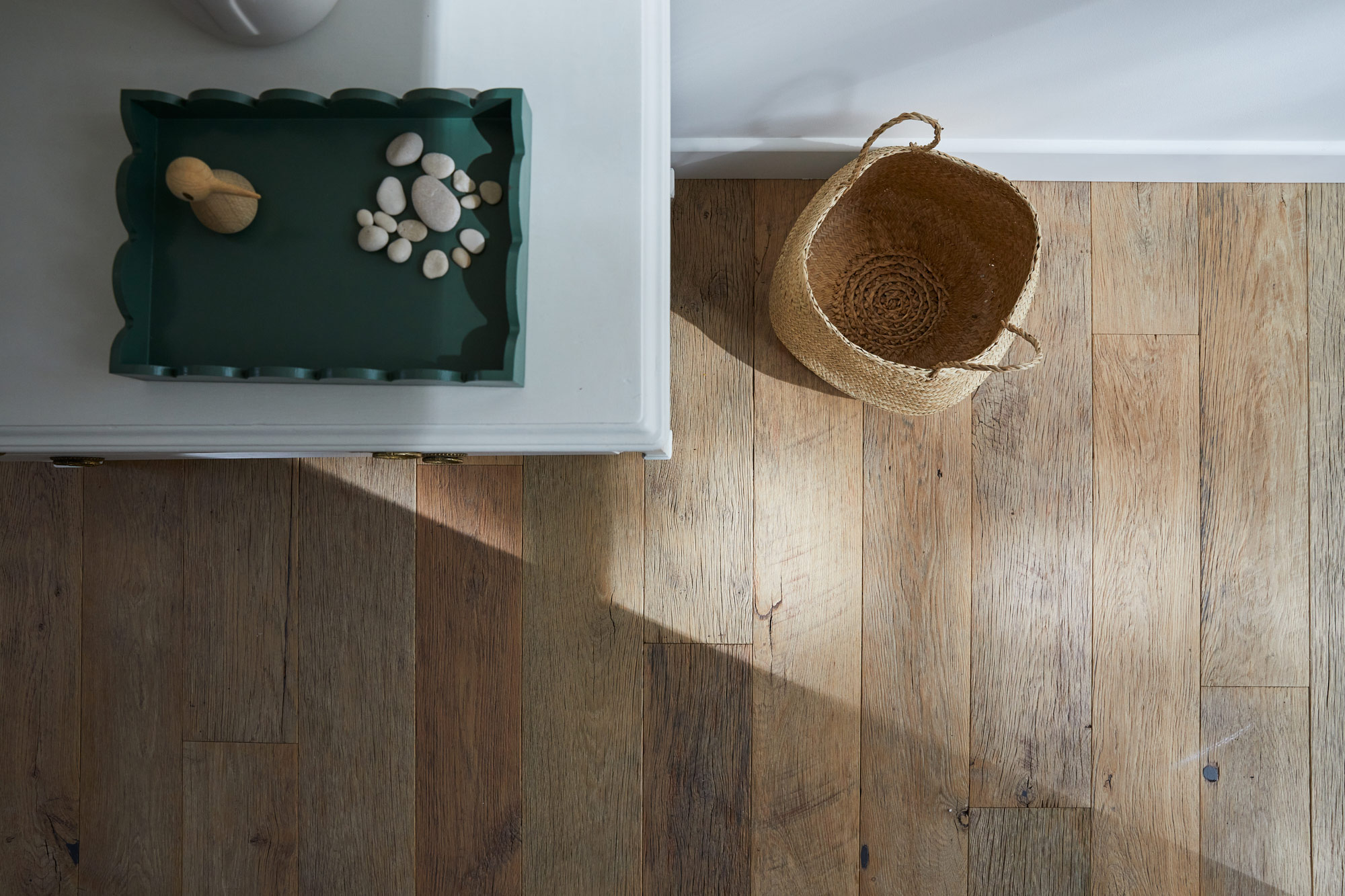 Sunlight casting a shadow across reclaimed wood flooring