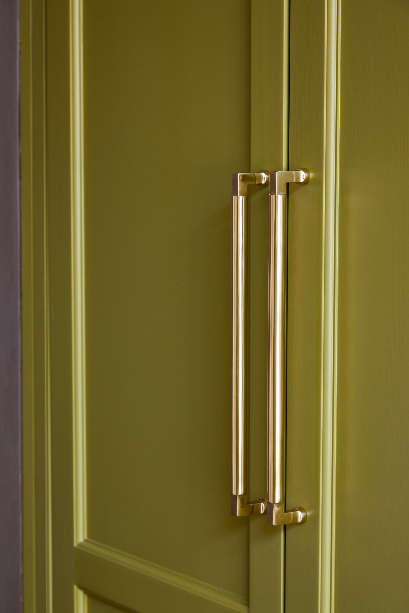 Long brass pull handles on kitchen larder