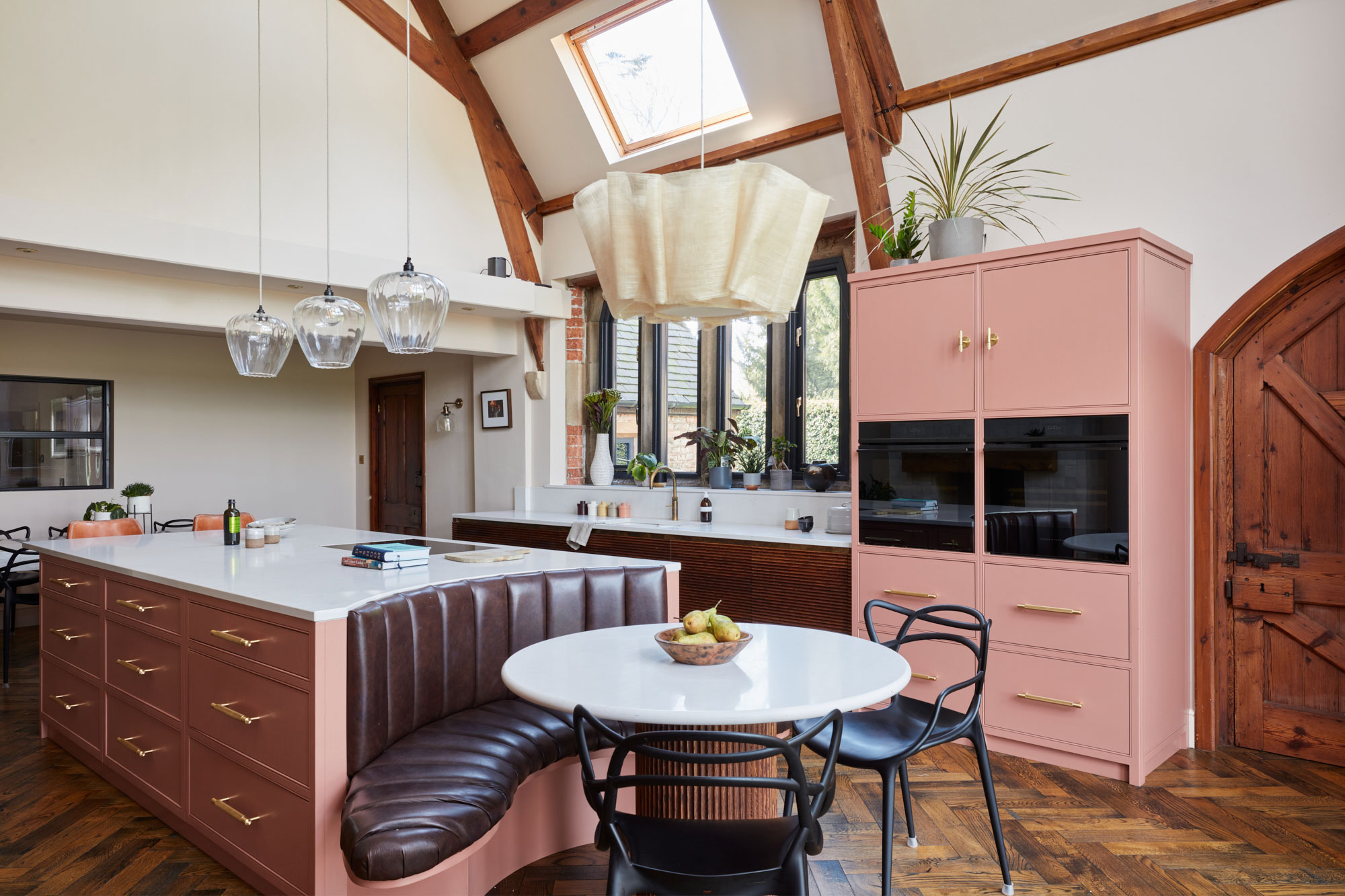 Open plan kitchen with large pink painted island