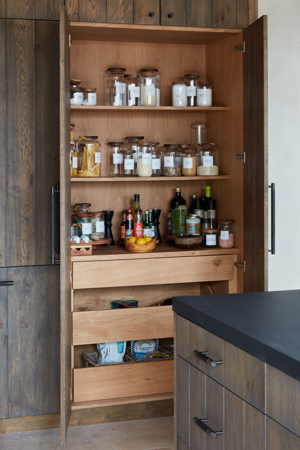 Clear containers with labels in kitchen pantry