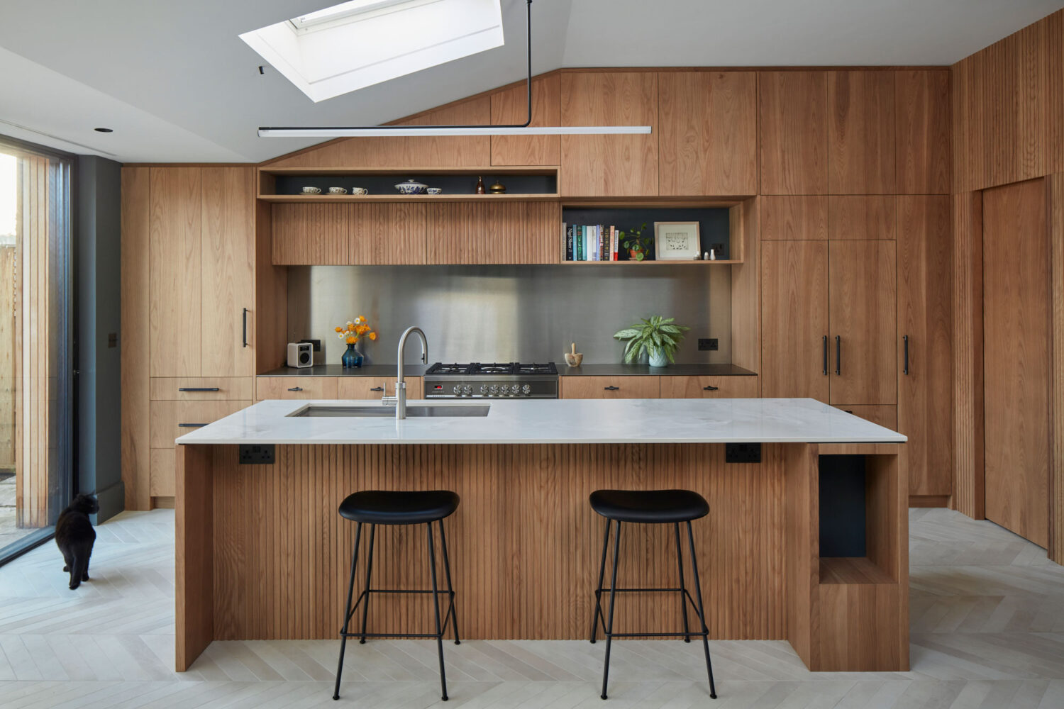 Kitchen with wooden cabinets and fluted details which has an island used for seating 