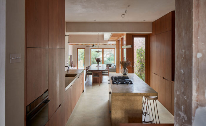 Open plan kitchen by The Main Company featuring concrete worktops and oak cabinets