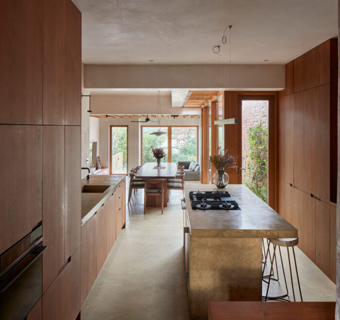 Open plan kitchen by The Main Company featuring concrete worktops and oak cabinets