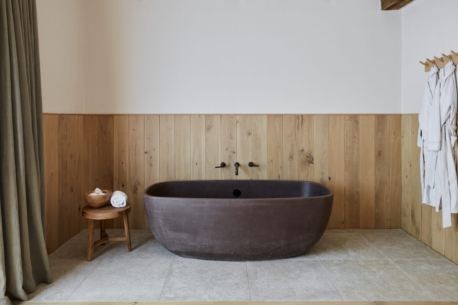 bathtub with wood cladding behind