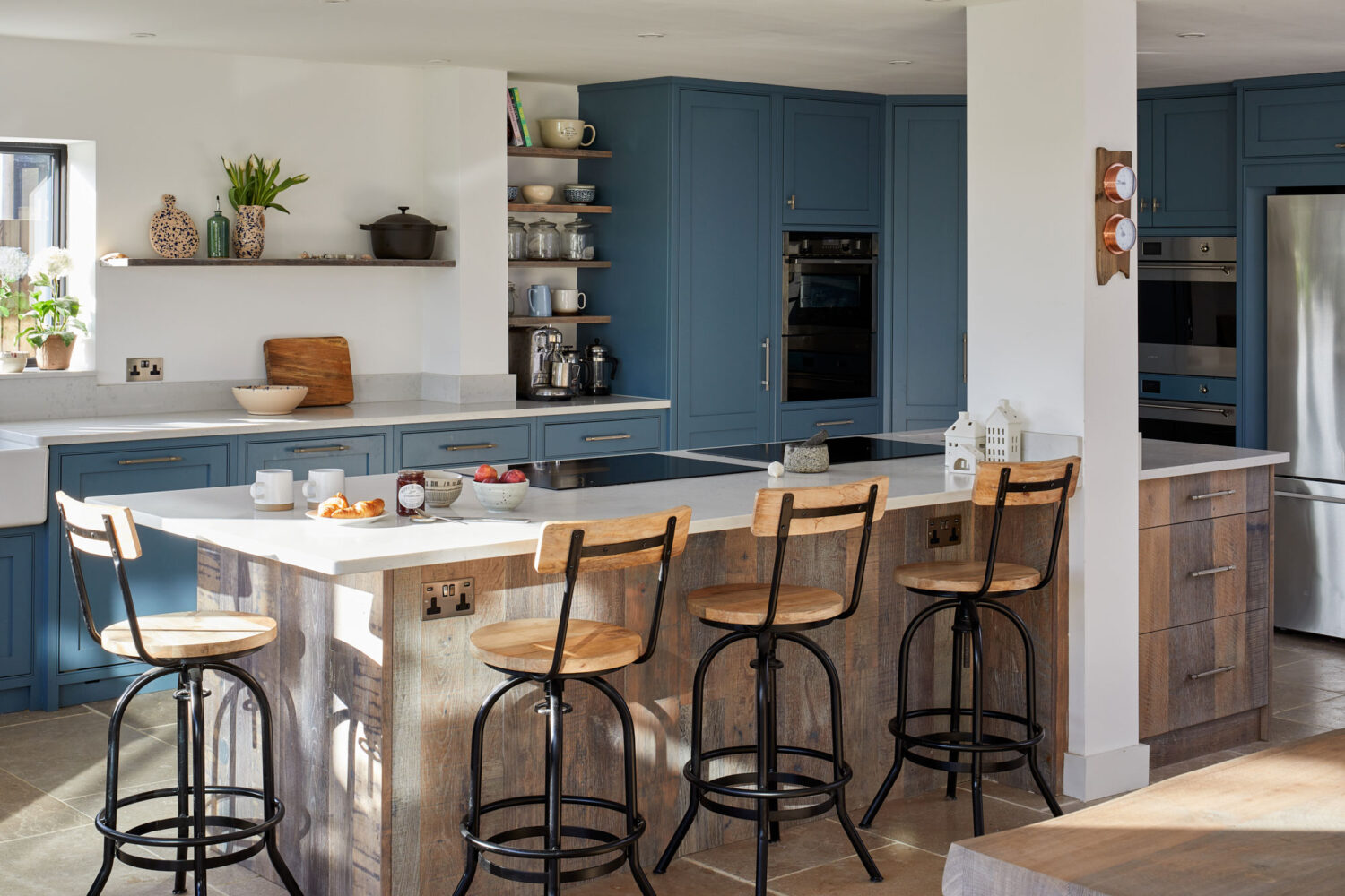 island kitchen with wood cabinets in a blue shaker style kitchen